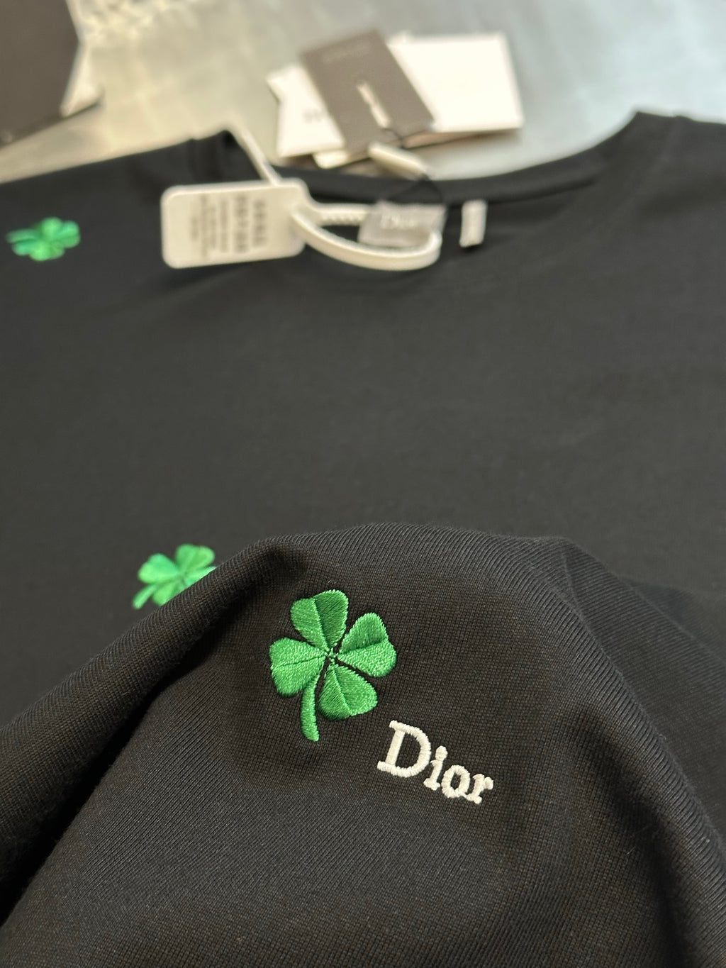 Dior dark T-shirt with green clover embroidery and Dior script on fabric