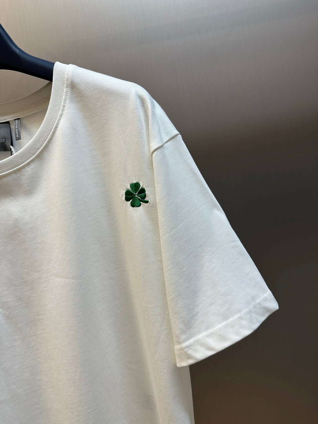 White short-sleeve T-shirt with green clover embroidery on sleeve