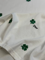 White T-shirt with green clover patches and 'Dior' printed emblem