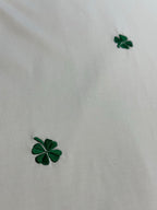 White T-shirt fabric with green four-leaf clover embroidery