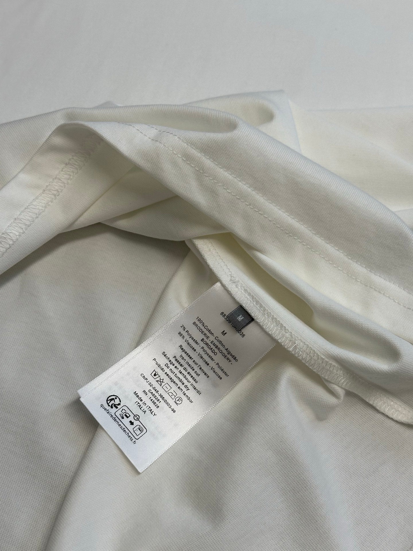 White T-shirt inside view with brand tags and crew neck seam