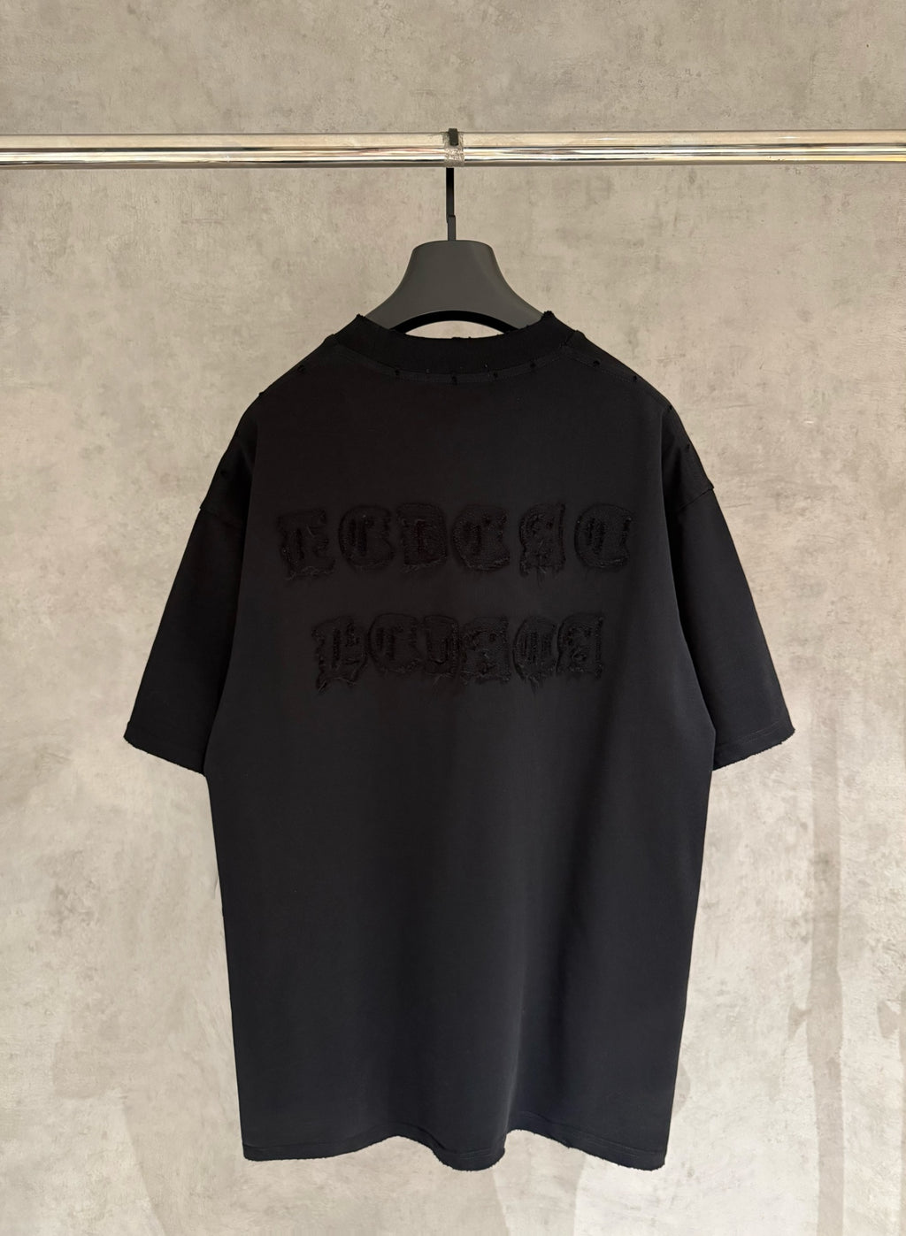 Black short-sleeve crewneck T-shirt with embossed logo graphic on back