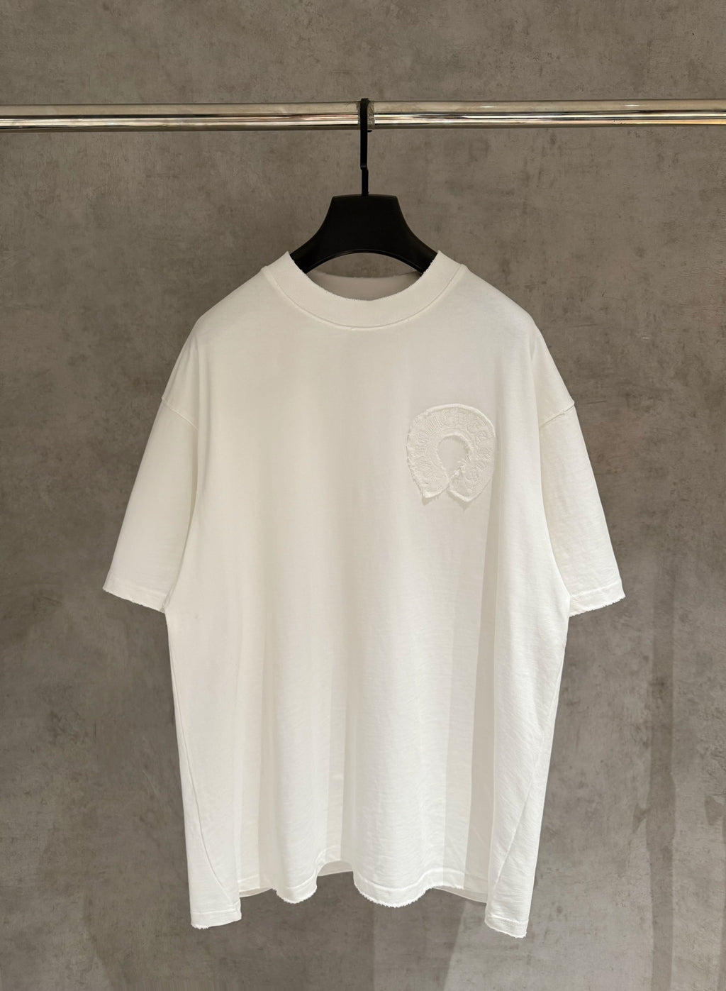 White crew-neck short-sleeve T-shirt with small raised embroidered logo on chest.