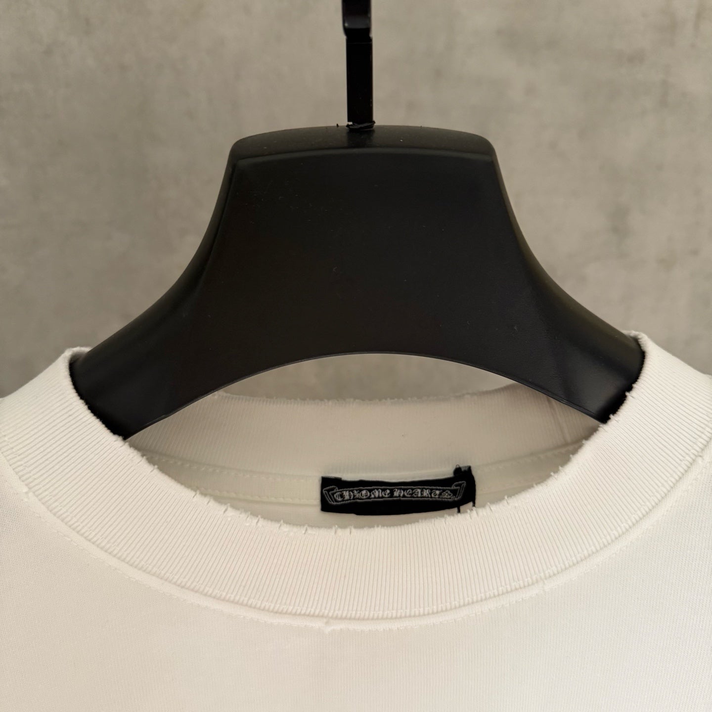 White crew-neck T-shirt collar with ribbed neckband and interior size label.