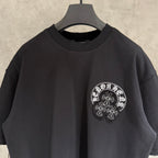 Black short-sleeve T-shirt with crew neck and small white circular chest graphic