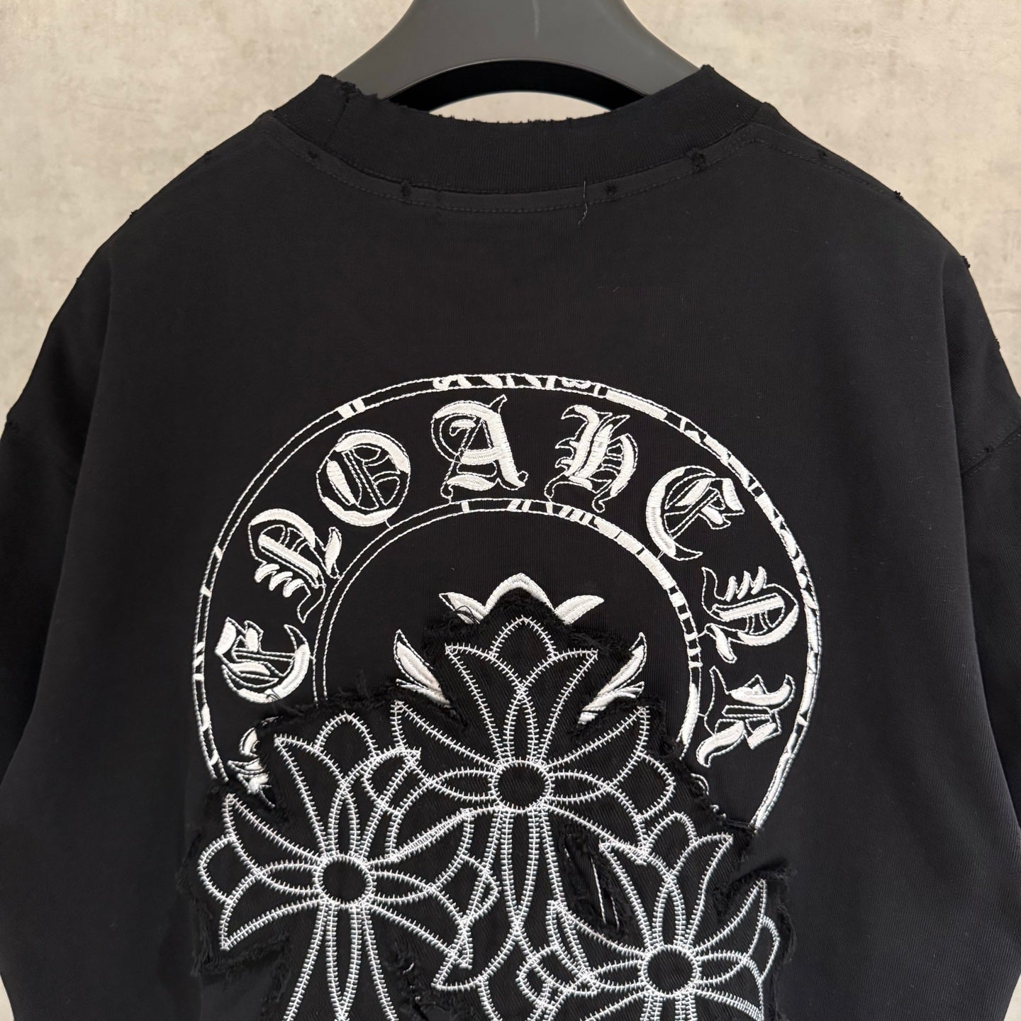 Black short-sleeve T-shirt with large white circular chest floral embroidery graphic