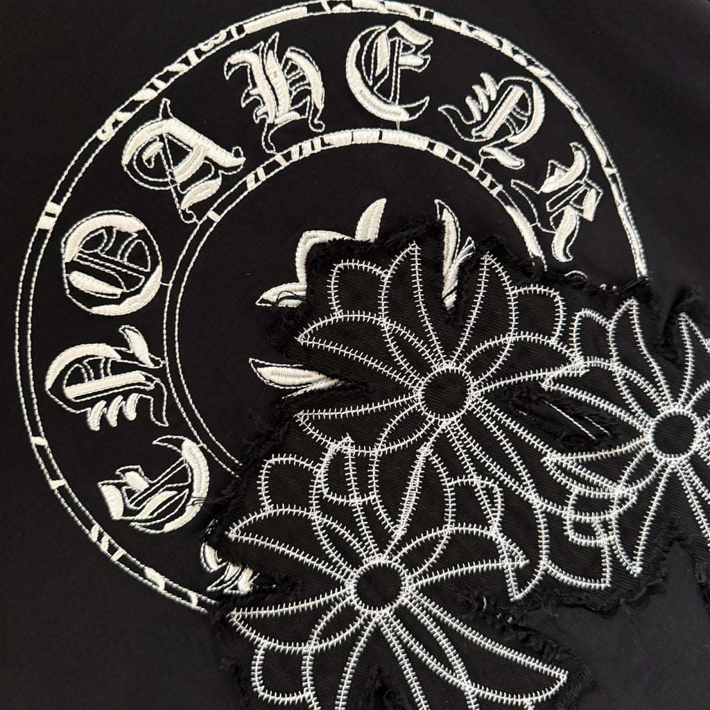 Close-up of white floral circular graphic on black short-sleeve T-shirt