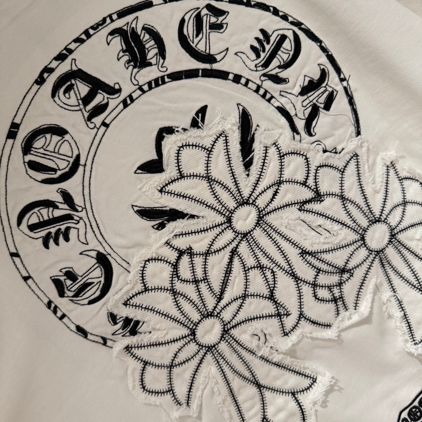 White back graphic wreath close-up with floral and stitched outline details