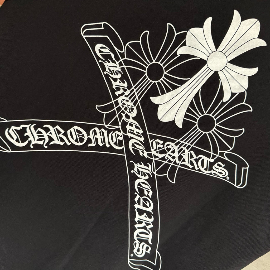 Black short-sleeve T-shirt close-up of white stylized cross graphic