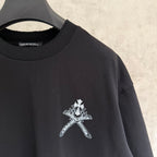 Black short-sleeve T-shirt with small white cross emblem on the front side