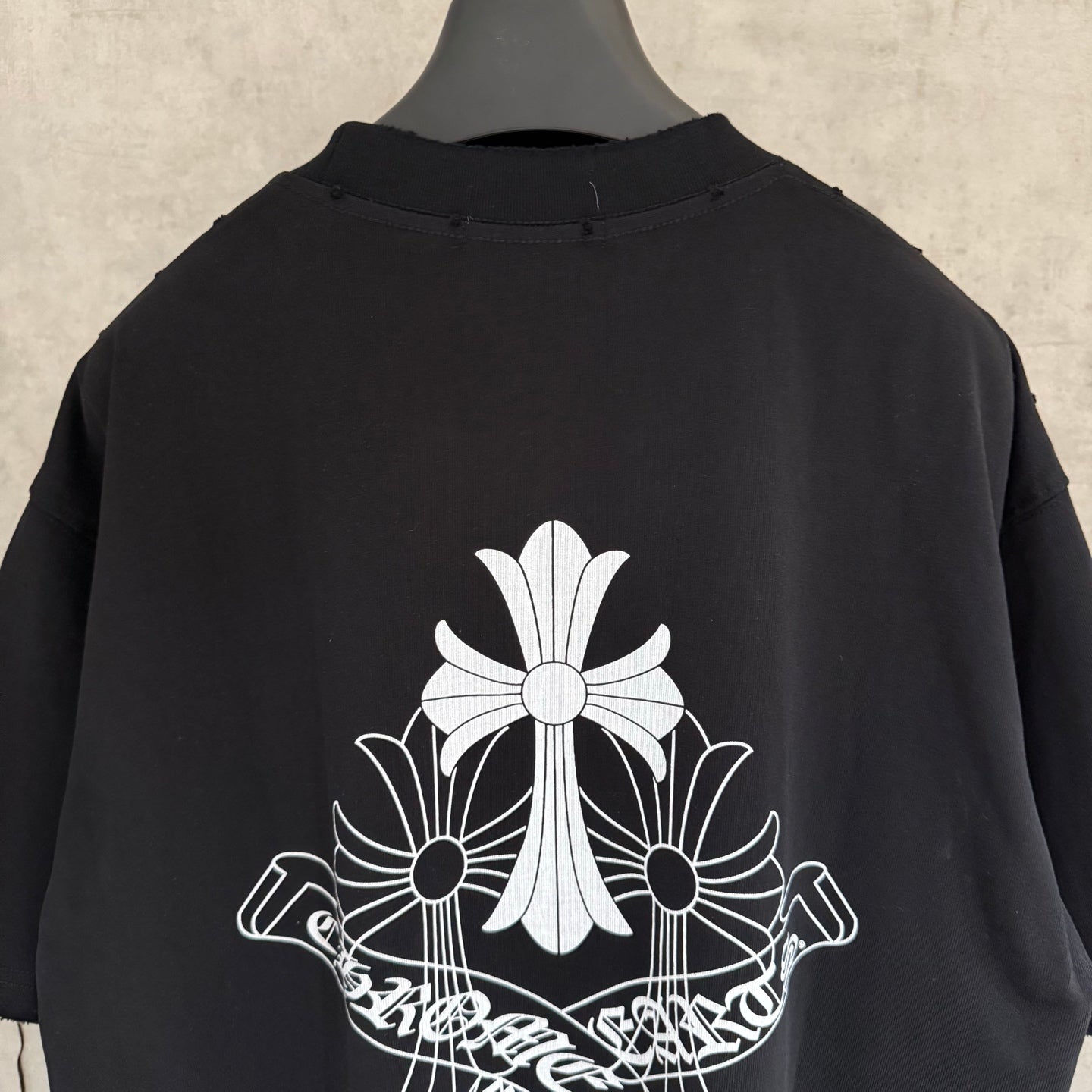 Black short-sleeve T-shirt back with large white floral cross graphic