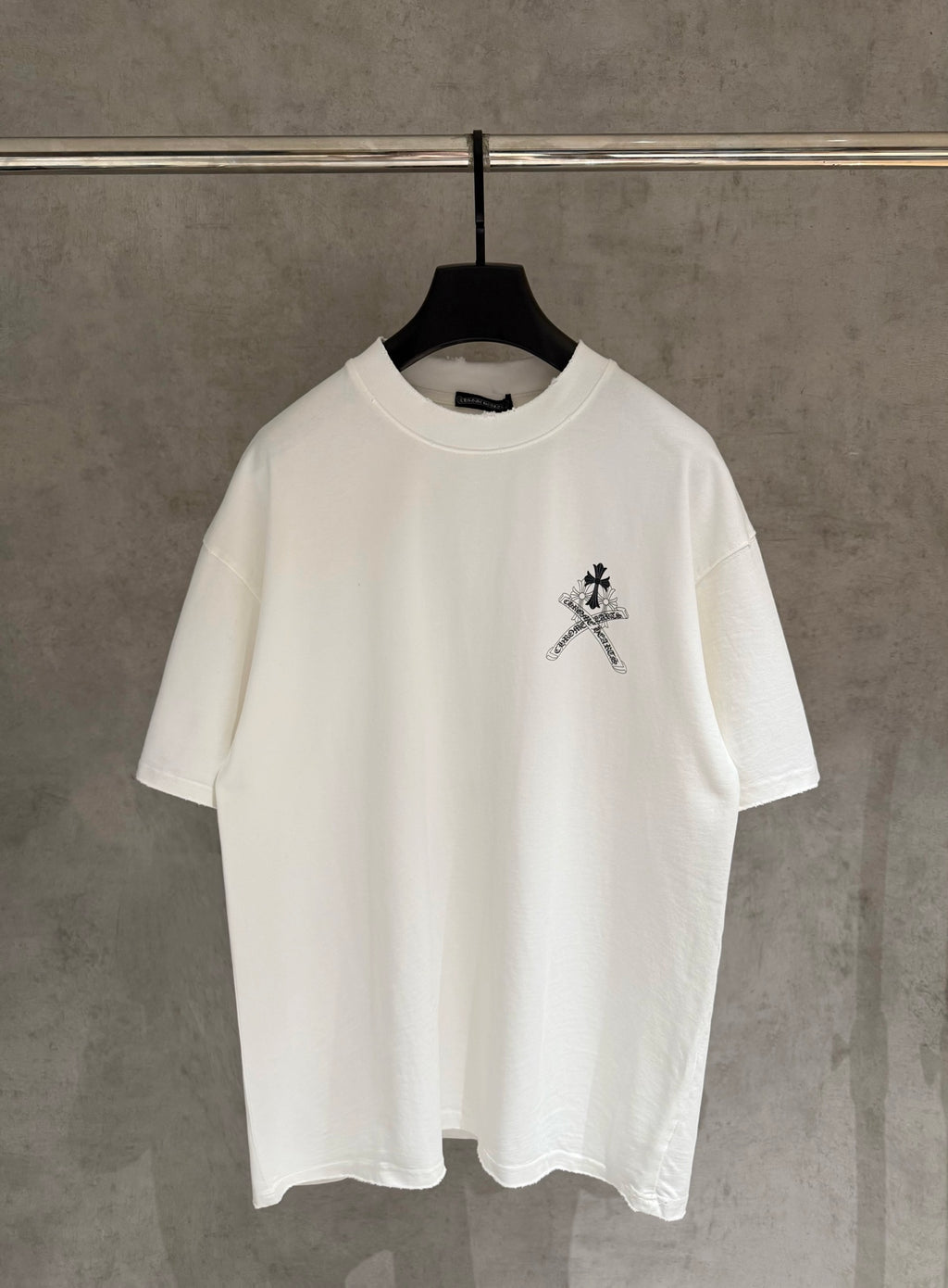 White short-sleeve T-shirt with small black sword-and-flower chest graphic