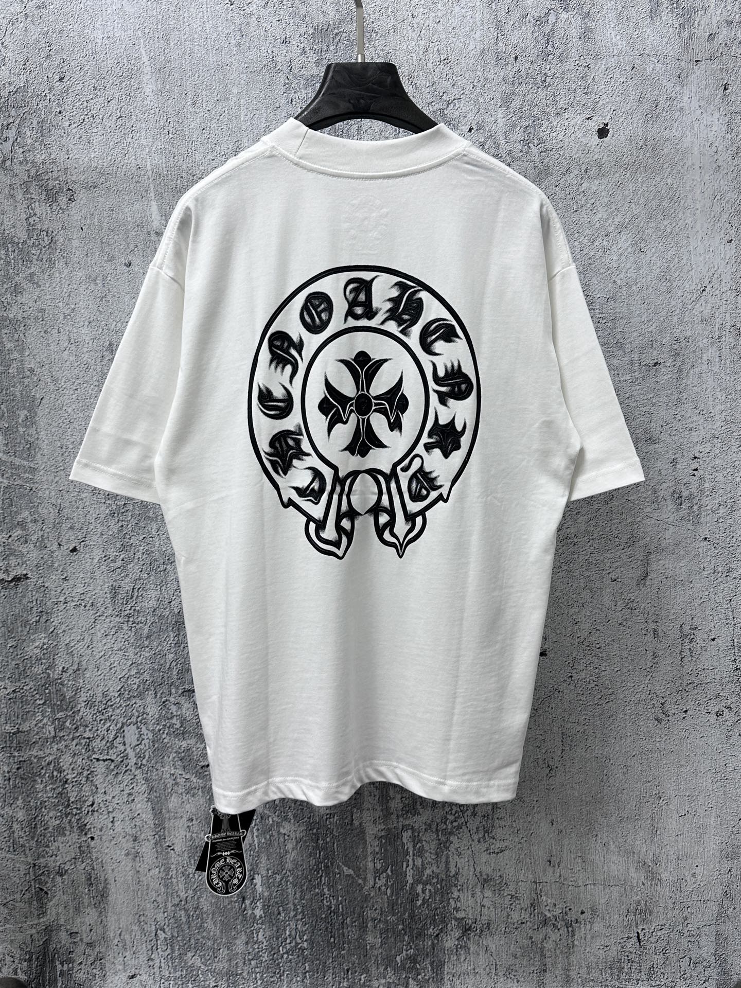 White short-sleeve T-shirt with large black circular skull graphic on the back