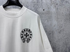 White short-sleeve T-shirt with small black circular skull graphic on the chest