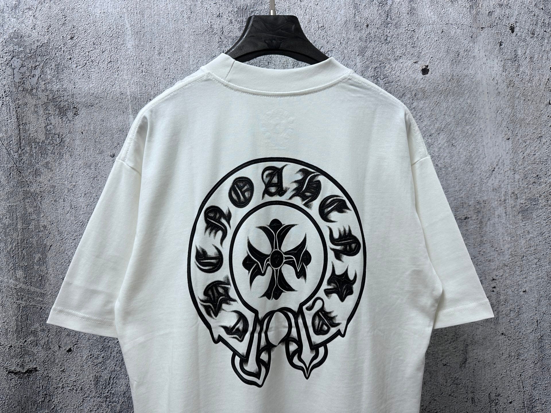 White short-sleeve T-shirt with large black circular skull graphic centered on the back