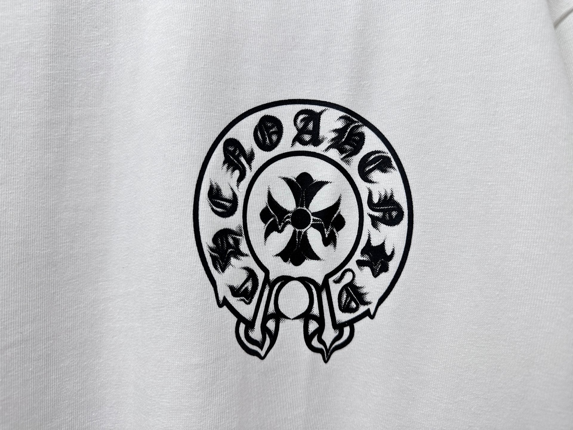 White T-shirt close-up of black circular skull graphic