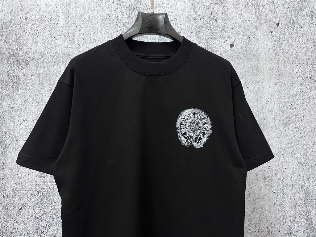 Black short-sleeve T-shirt with small circular chrome-style chest graphic