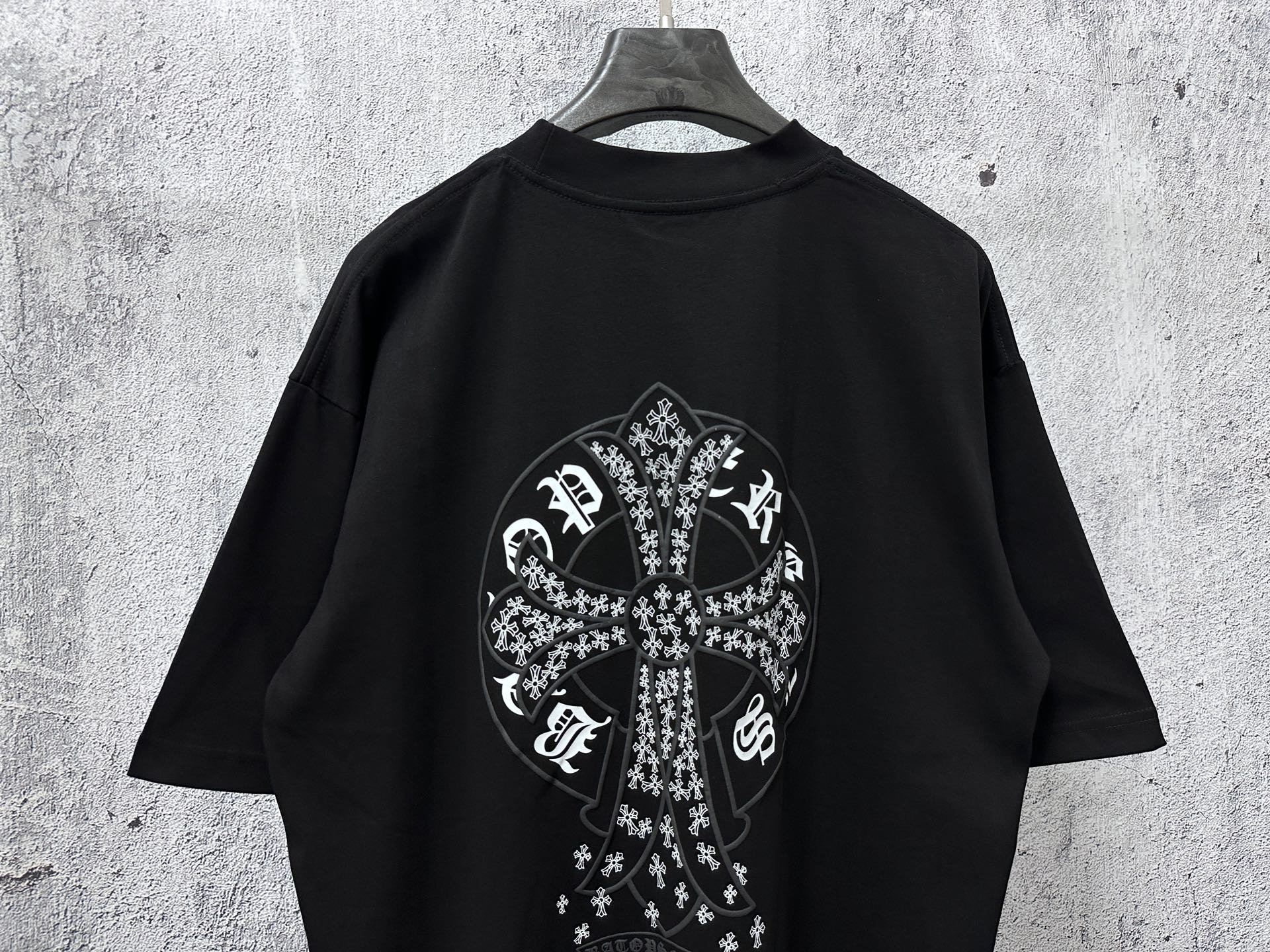 Black short-sleeve crewneck T-shirt with large white cross graphic on back