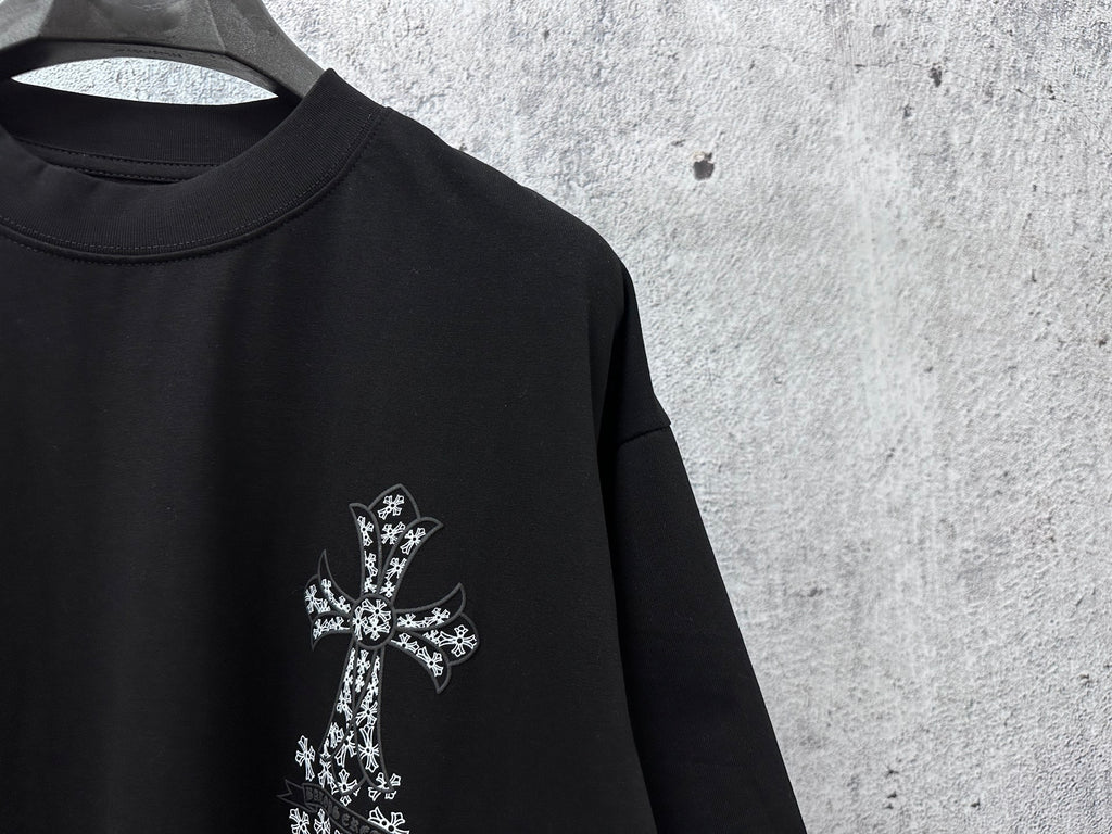 Black short-sleeve crewneck T-shirt close-up of small white cross chest graphic