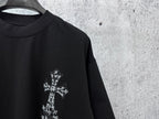 Black short-sleeve crewneck T-shirt close-up of small white cross chest graphic