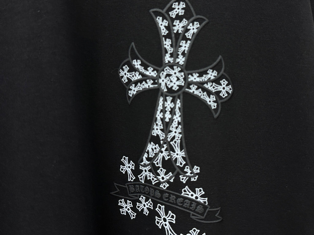 Black T-shirt close-up of white cross graphic with ornate pattern