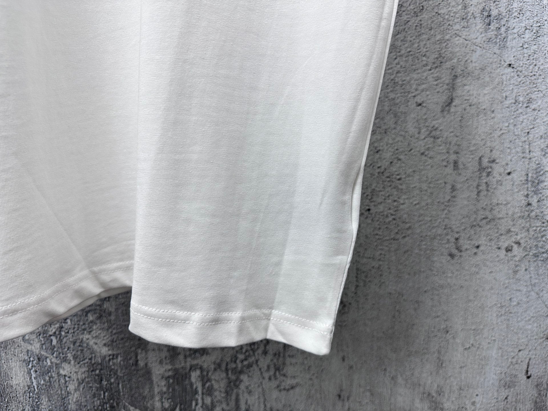 White T-shirt hem and side seam detail under short sleeves