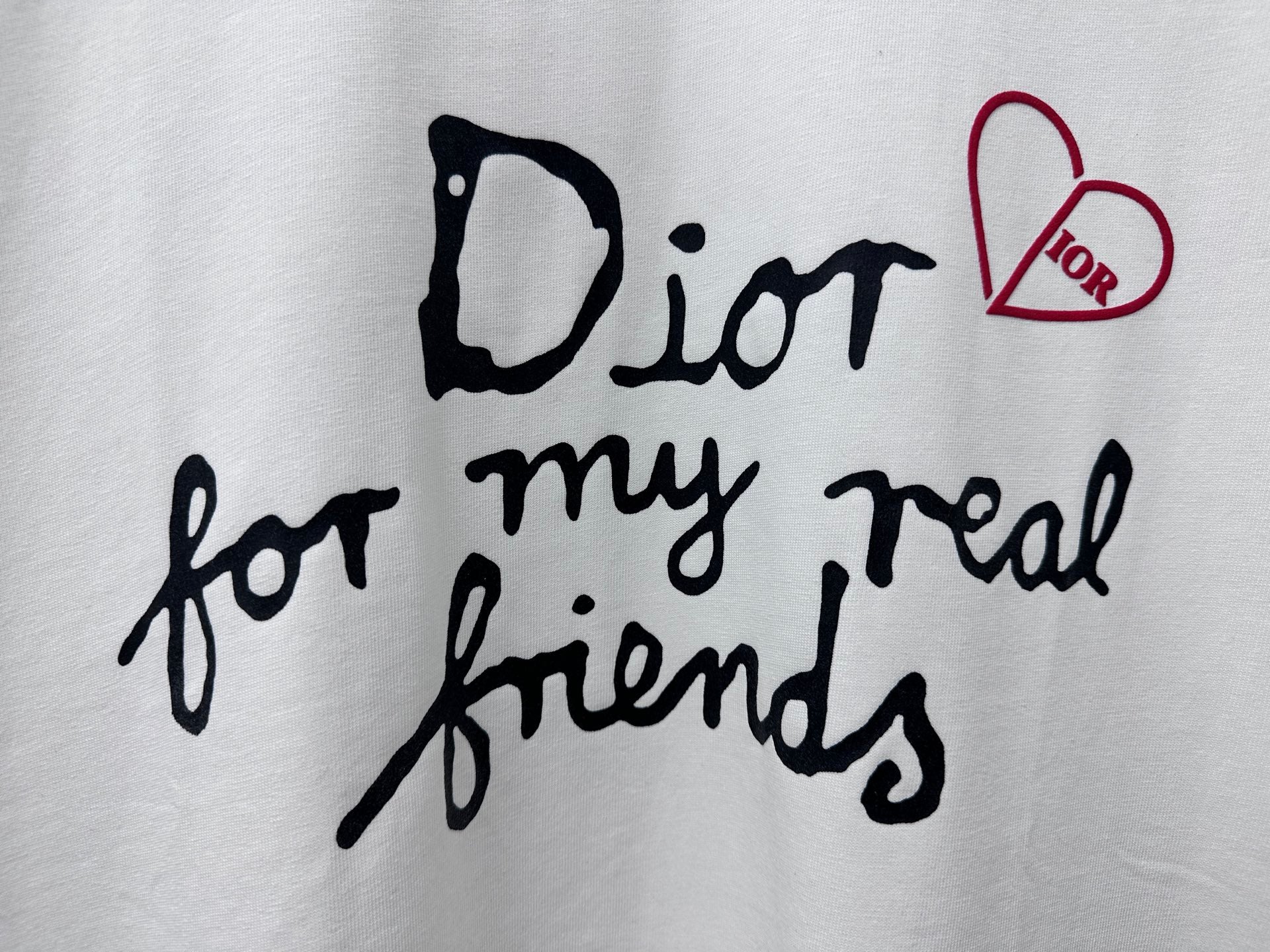 White T-shirt front graphic close-up: black script and red heart