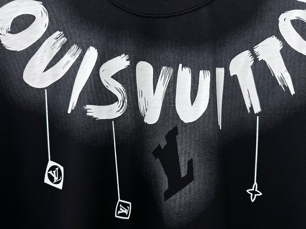 Close-up white graffiti lettering and charm graphic on black T-shirt