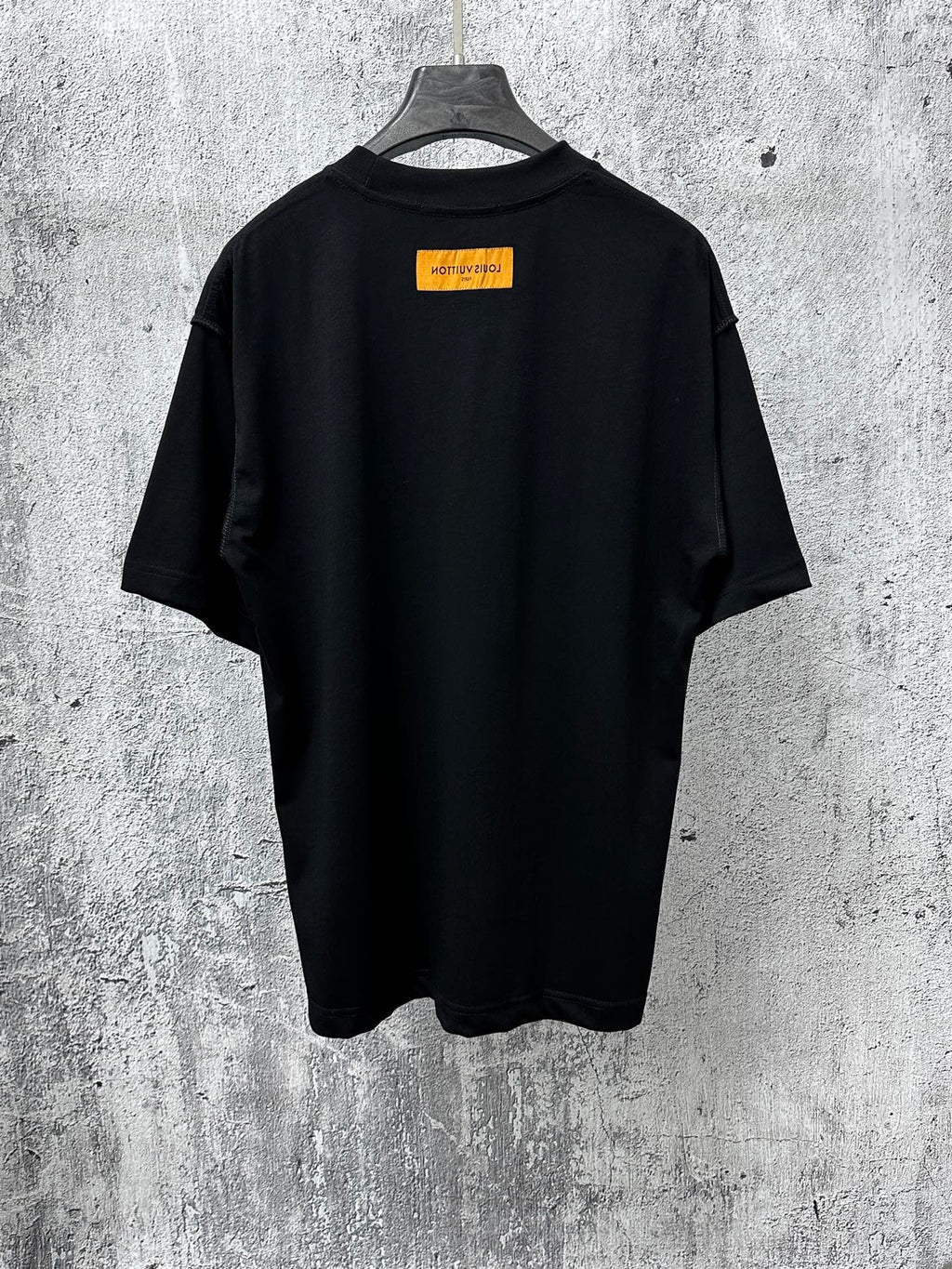 Back view short-sleeve black T-shirt with orange rectangular logo label