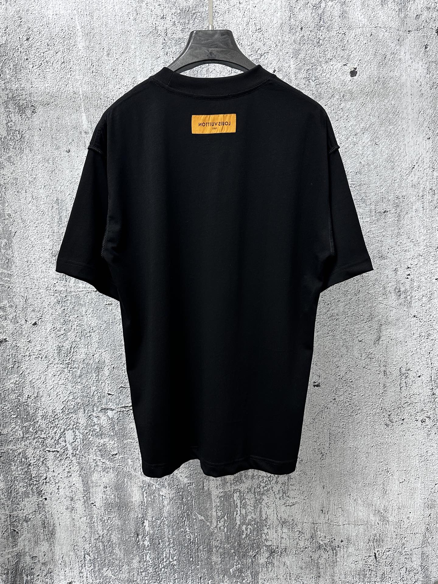 Back view short-sleeve black T-shirt with orange rectangular logo label