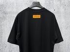 Back view short-sleeve black T-shirt with orange logo label near collar