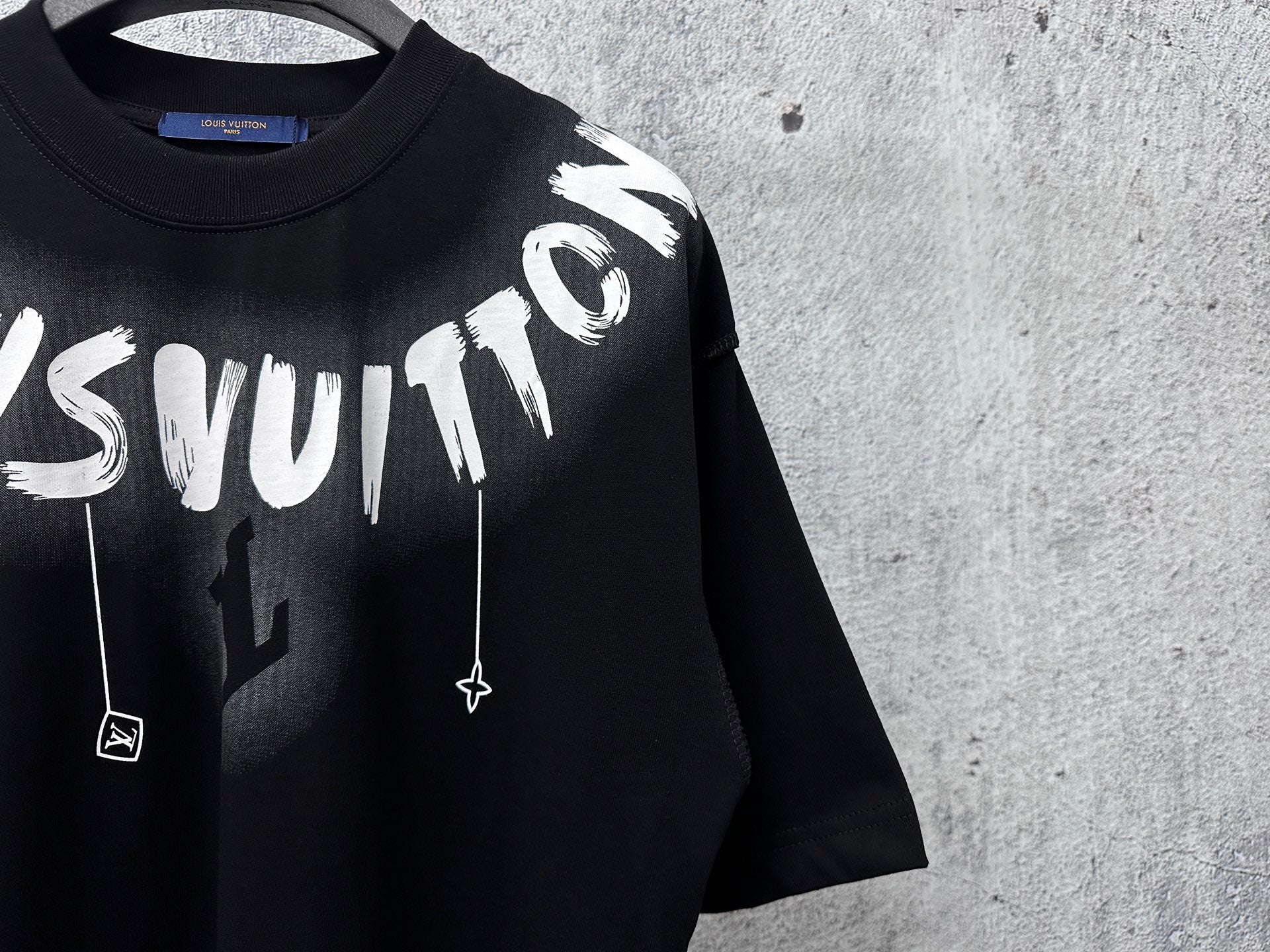 Close-up black short-sleeve T-shirt with large white graffiti lettering