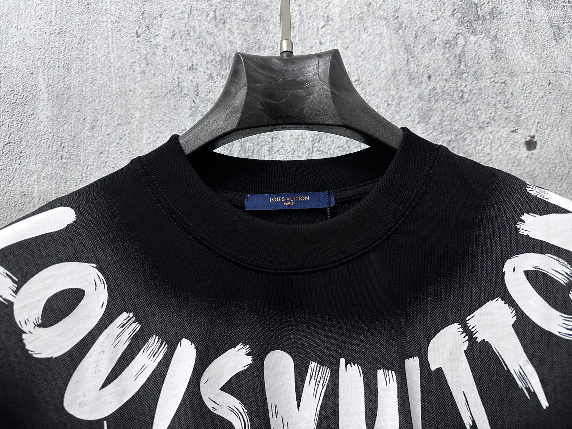 Close-up short-sleeve black T-shirt neckline with white graffiti print