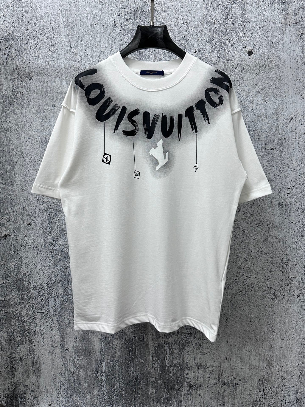 White T-shirt with black “Louisvuitton” graphic print and small charm icons