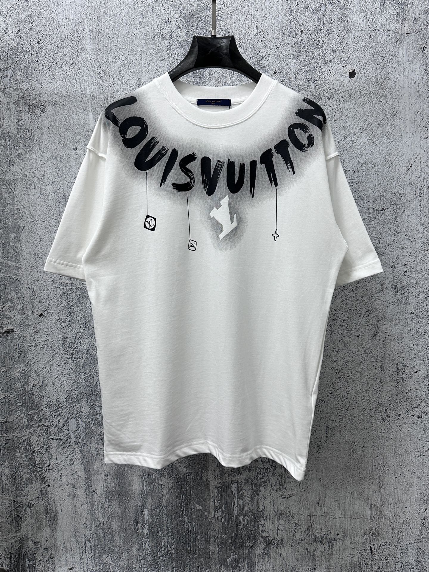 White T-shirt with black “Louisvuitton” graphic print and small charm icons