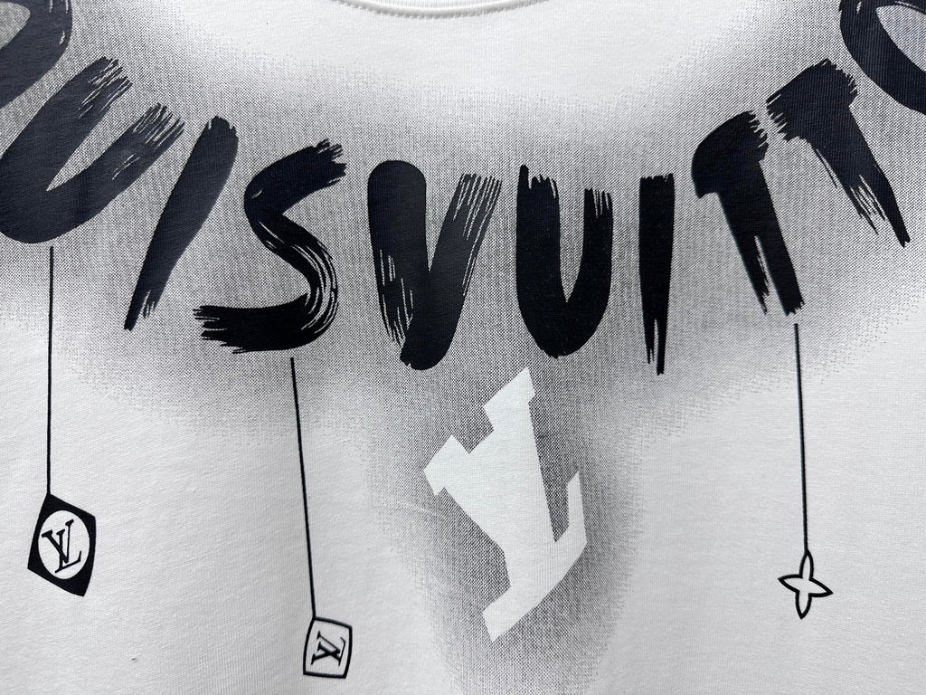 White T-shirt close-up with black “Louisvuitton” text and hanging charm icons