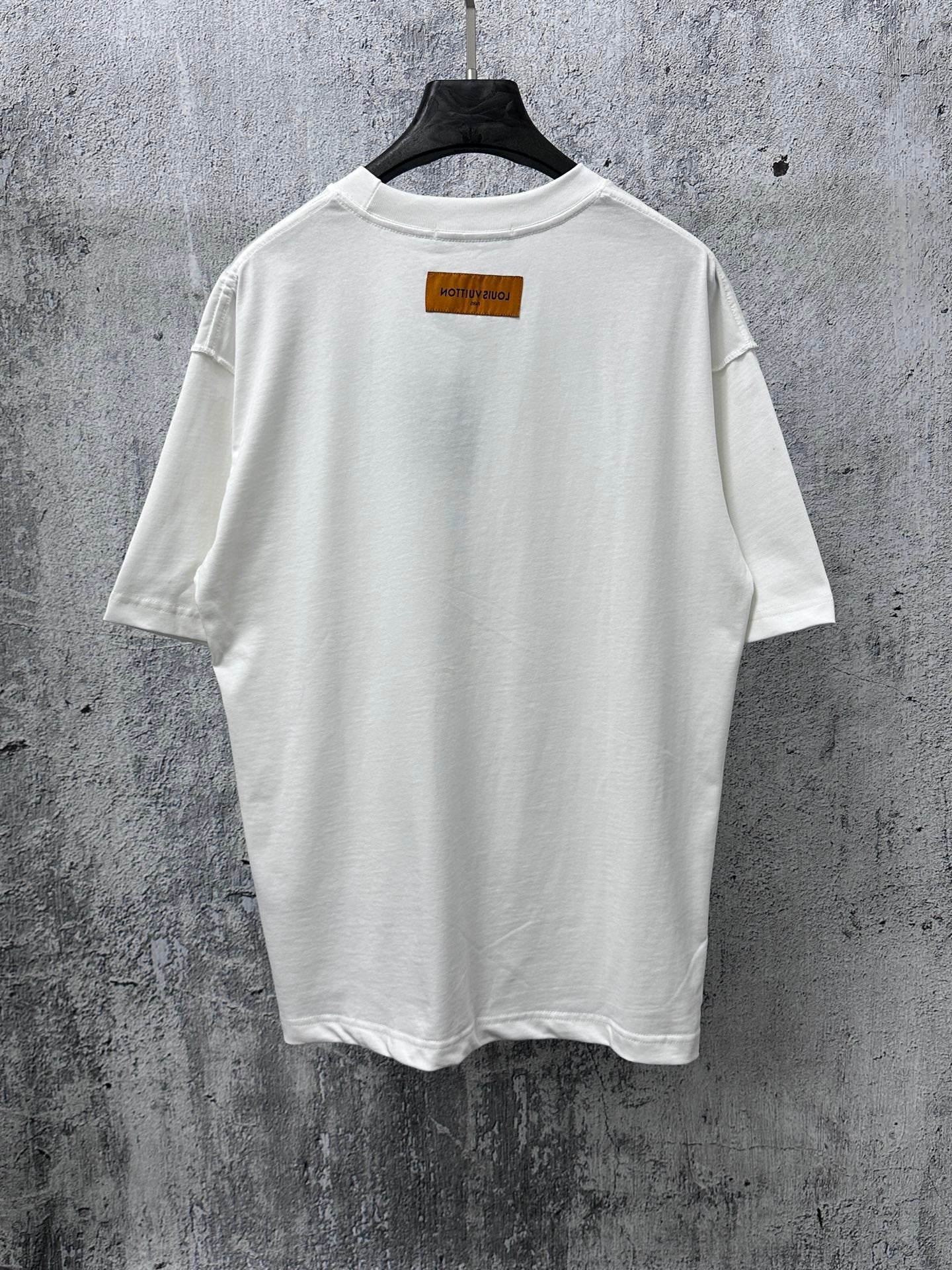 White T-shirt, plain back with small rectangular brand label near the collar