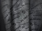 Balenciaga T-shirt fabric close-up, black with repeating Balenciaga logo pattern
