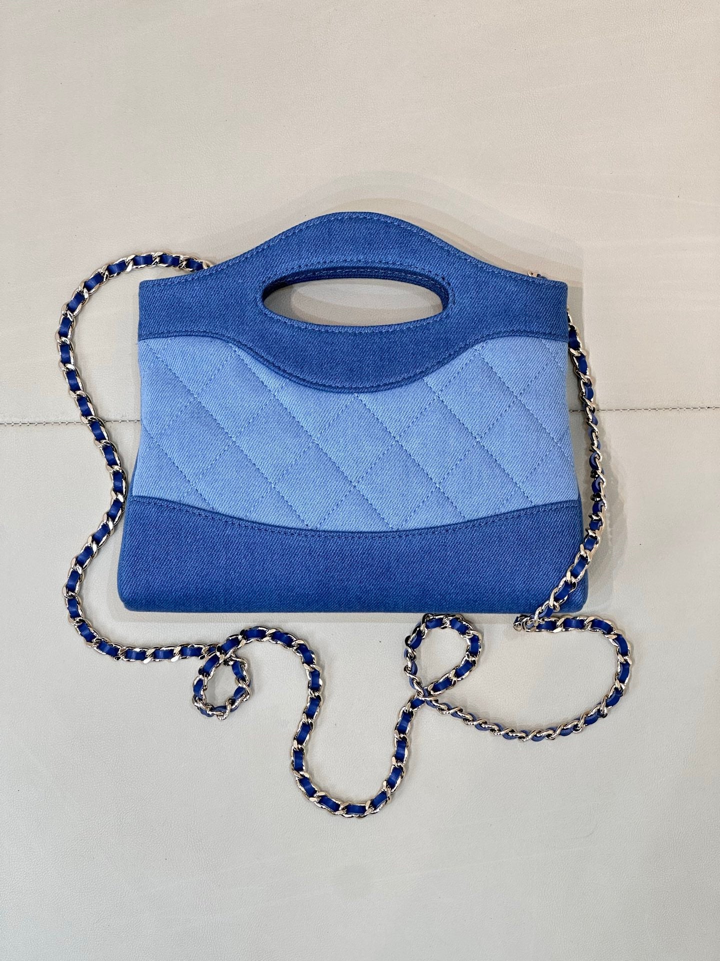Chanel blue quilted mini bag with top handle cutout and braided chain shoulder strap