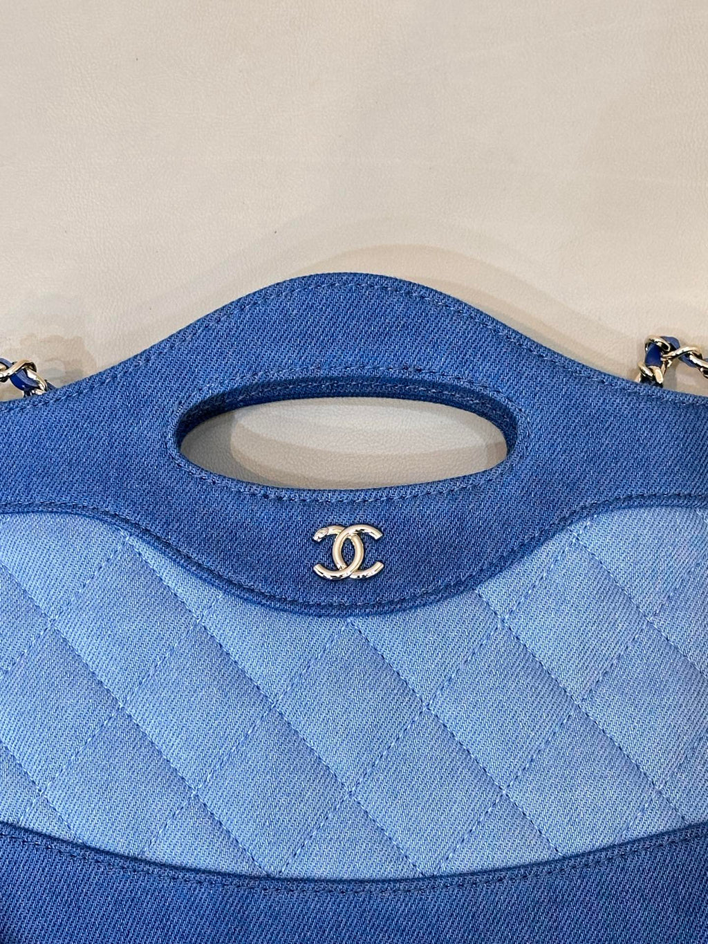 Chanel blue quilted bag close-up of oval handle cutout and stitched fabric