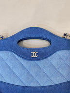Chanel blue quilted bag close-up of oval handle cutout and stitched fabric