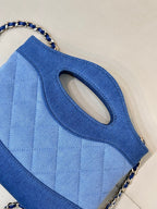 Chanel blue quilted bag close-up of oval handle cutout and chain strap