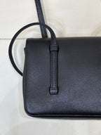 Chanel handbag close-up of side strap loop and textured dark blue leather body.