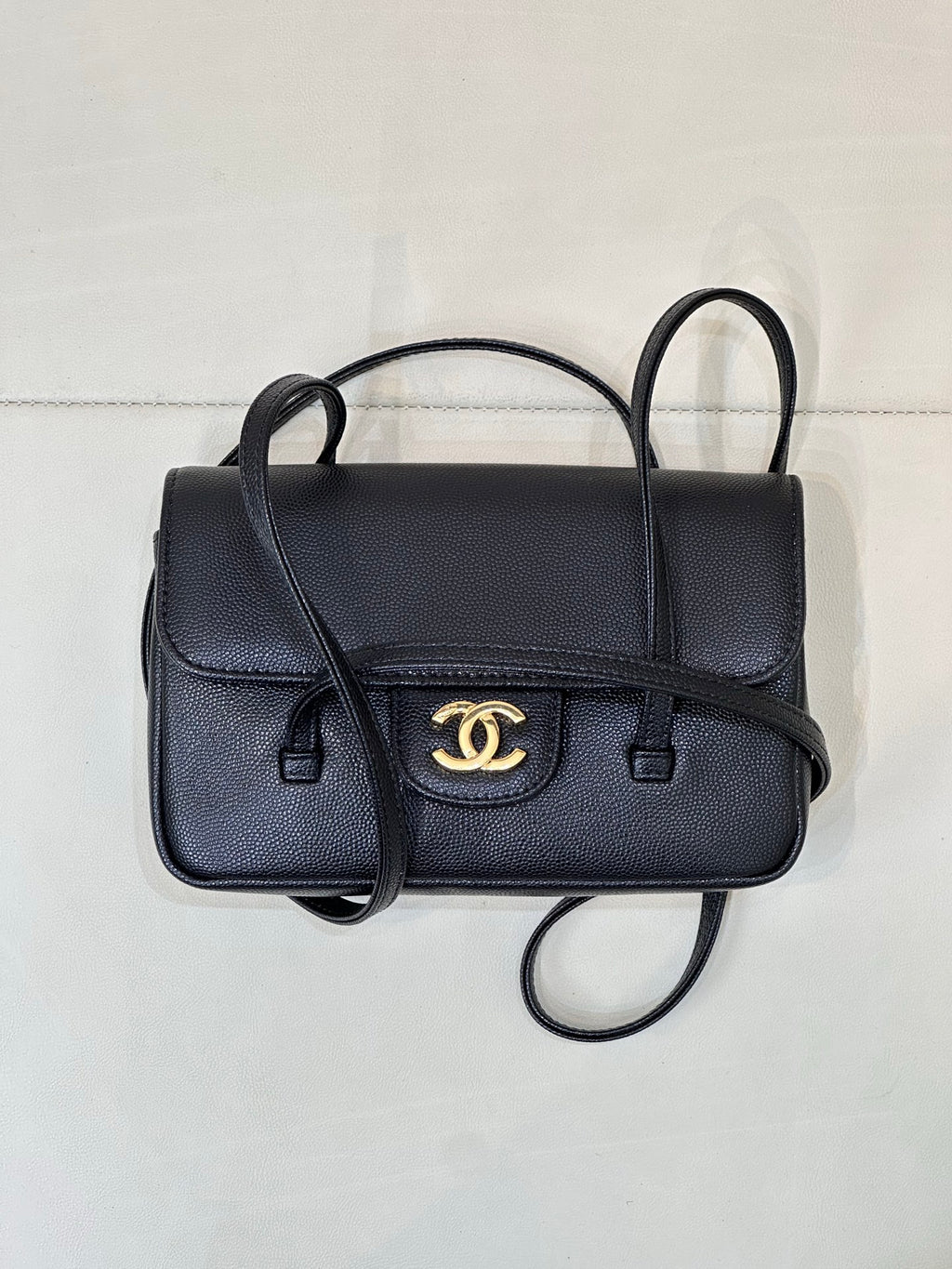 Chanel handbag with flap front, gold CC logo, and dual top handles with crossbody strap.
