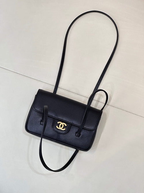 Chanel handbag with flap front and gold CC logo, shown with long shoulder strap.