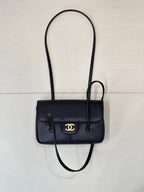 Chanel handbag with flap front, gold CC logo, top handle, and crossbody strap.