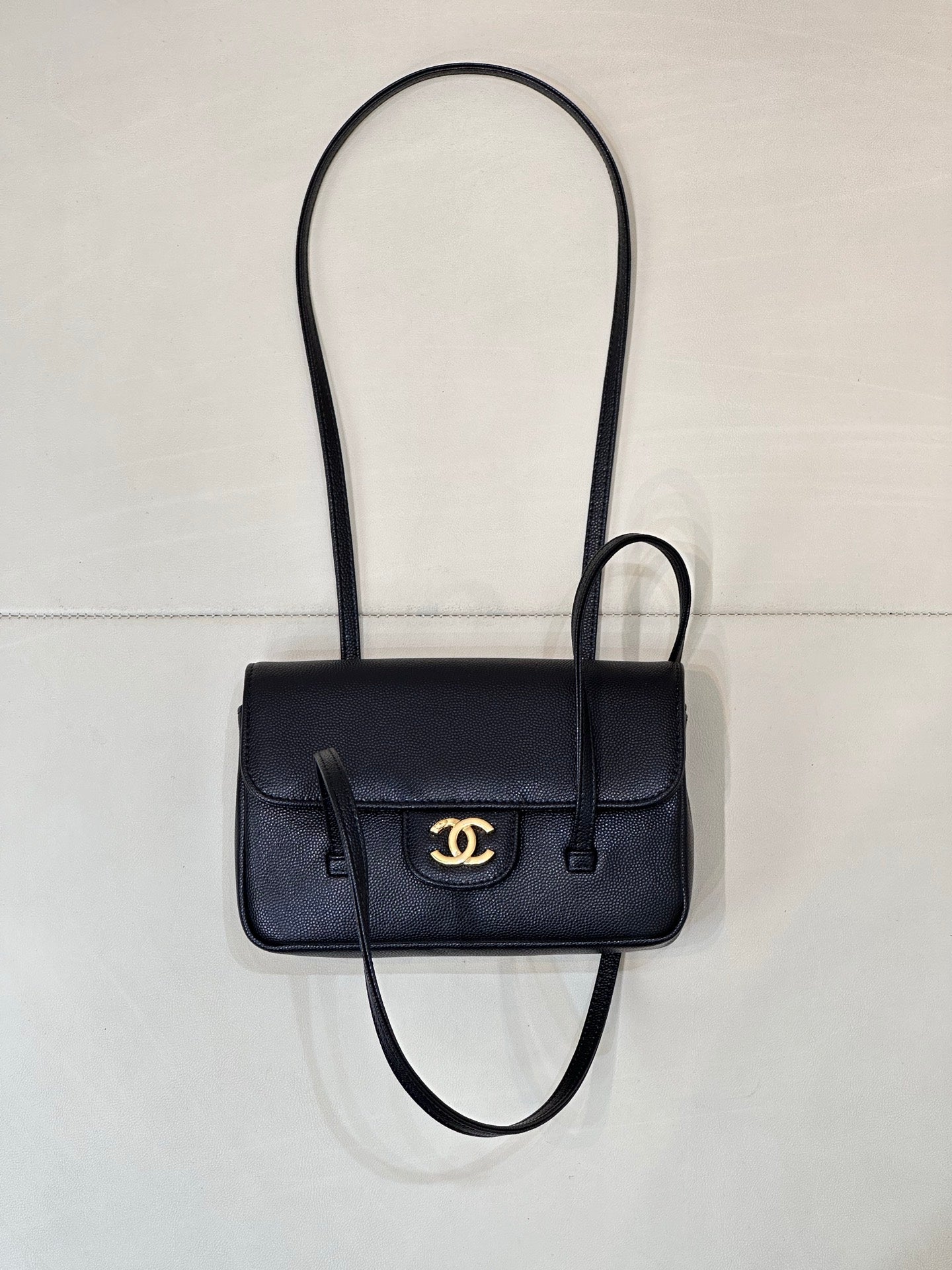 Chanel handbag with flap front, gold CC logo, top handle, and crossbody strap.