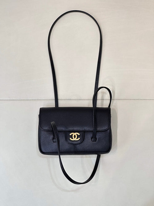 Chanel handbag with flap front, gold CC logo, top handle, and crossbody strap.