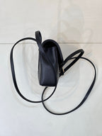 Chanel handbag side view showing top opening and crossbody strap.