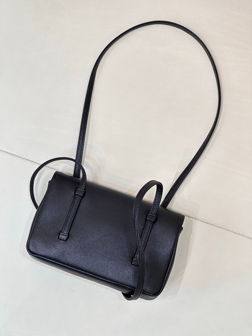 Chanel handbag front view with flap and strap loops, dark blue textured leather.